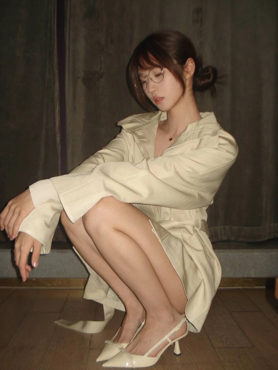 一位戴着眼镜和一件白色衬衫的女人倾斜在墙上。