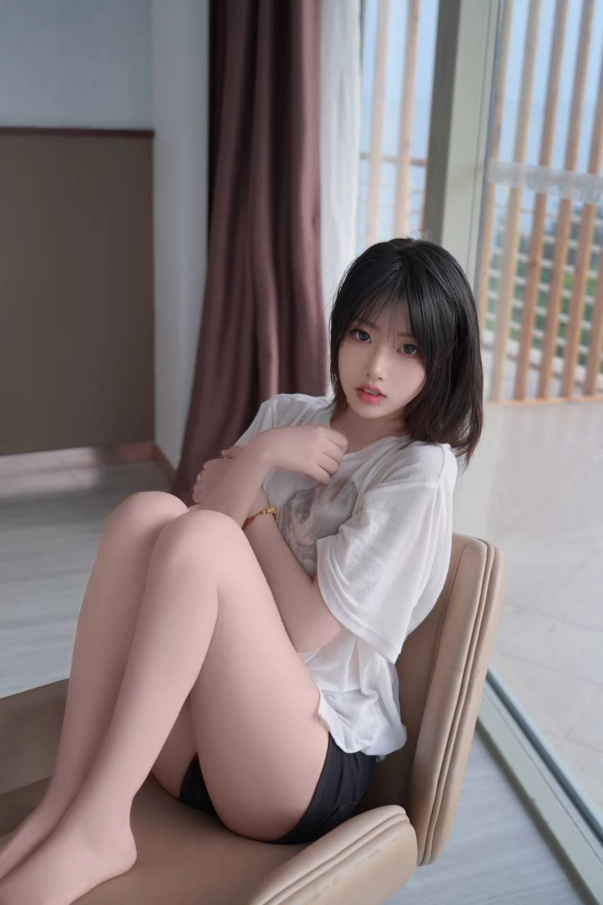 女人坐在椅子上,手放在脸上。