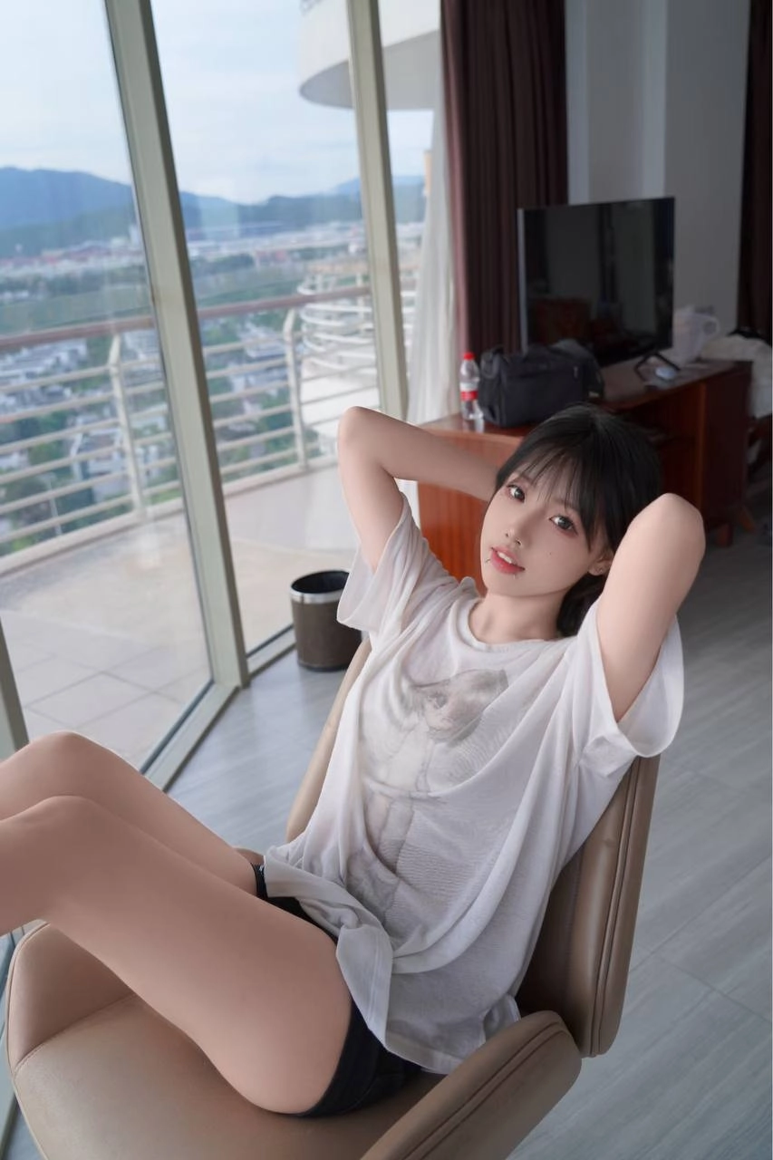 女人坐在椅子上,手放在脸上。