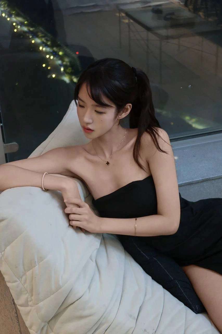 穿着黑色裙子的女人坐在沙发上。