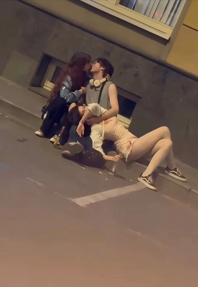 三个人在街上接吻。