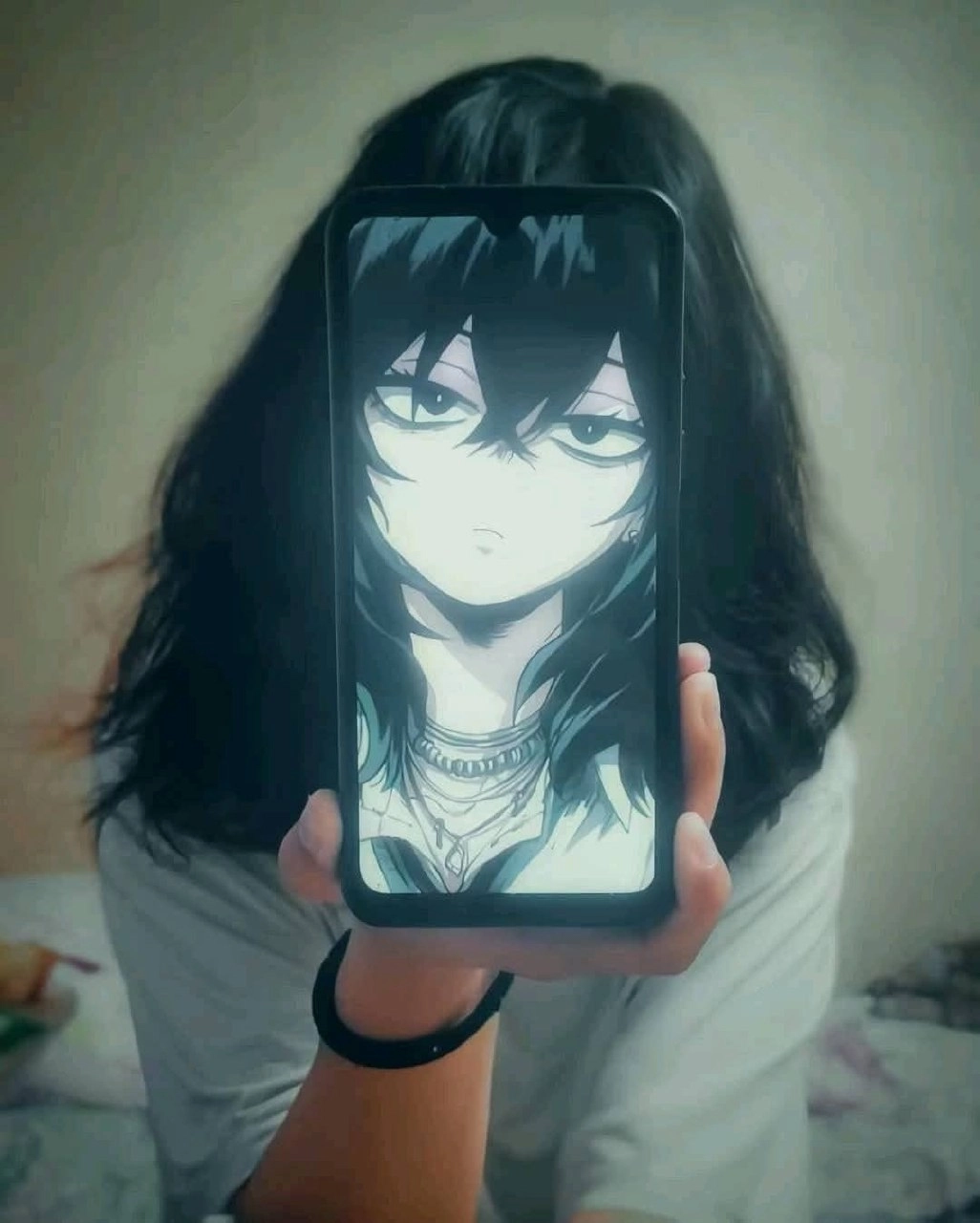 持有手机的人,上面有一张卡通脸。