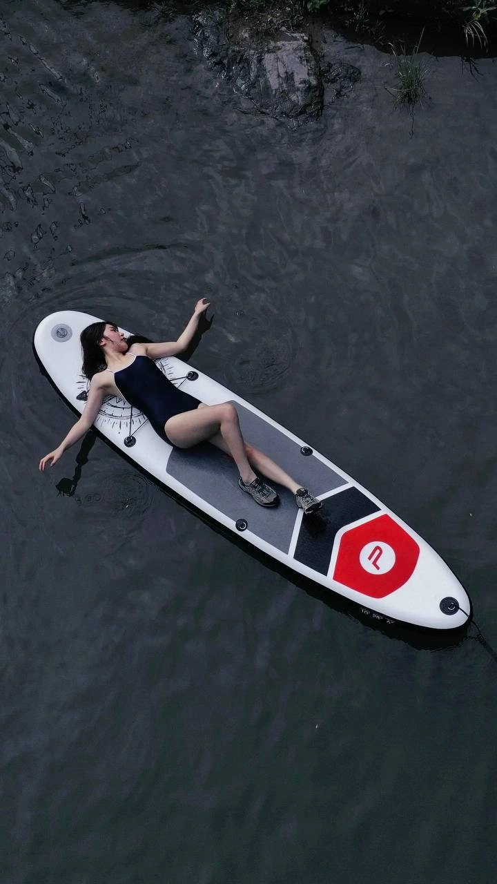 人躺在水中的冲浪板上。