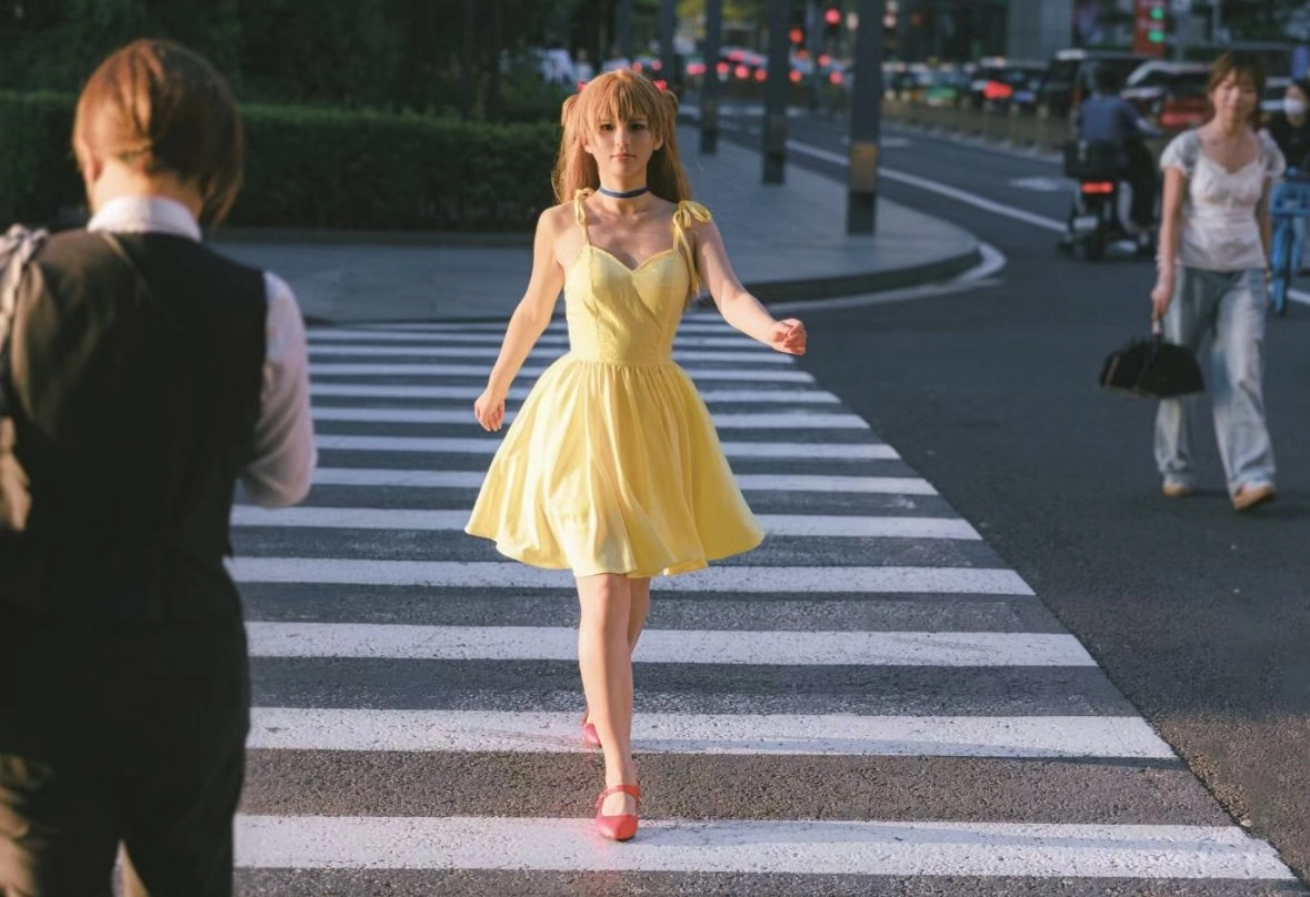 穿着黄色衣服的女人穿过一道街道。