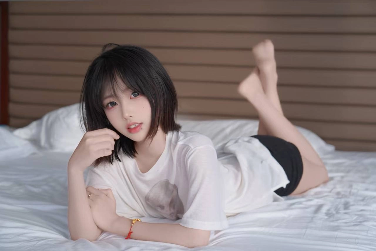 黑头发和白衬衫的女人躺在床上。