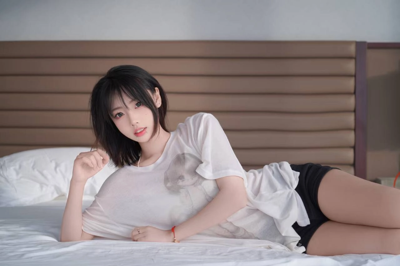 黑头发和白衬衫的女人躺在床上。