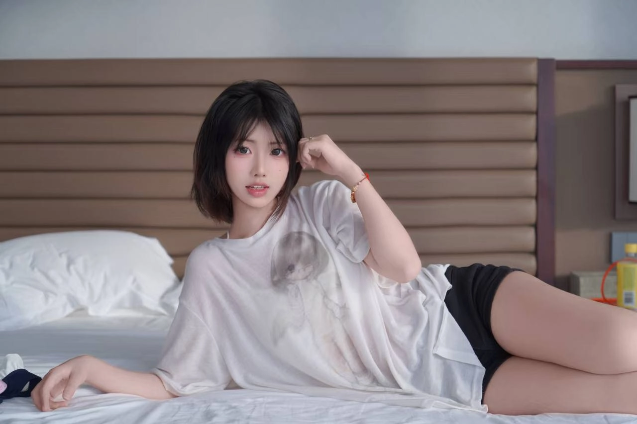 黑头发和白衬衫的女人躺在床上。