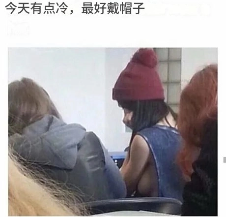 穿红帽的女人坐在一张桌子上。