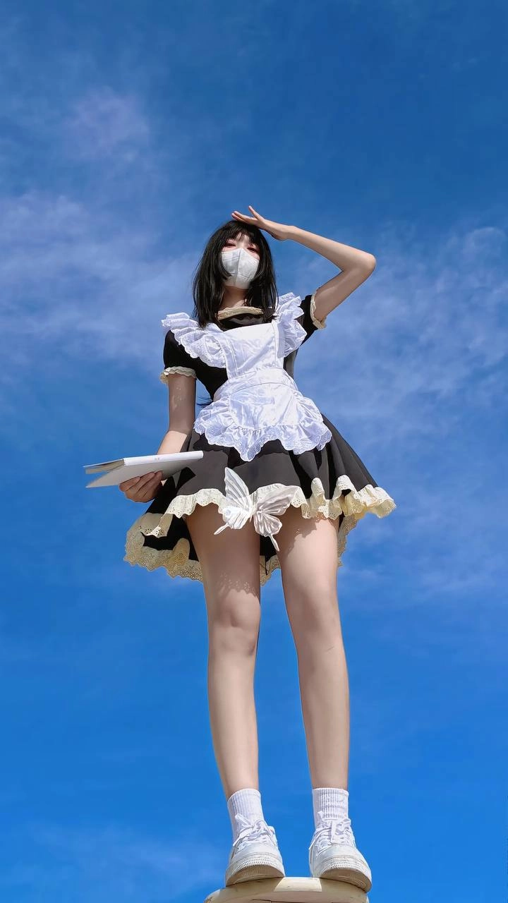 戴着面具和女仆服装的女人站在天空中。