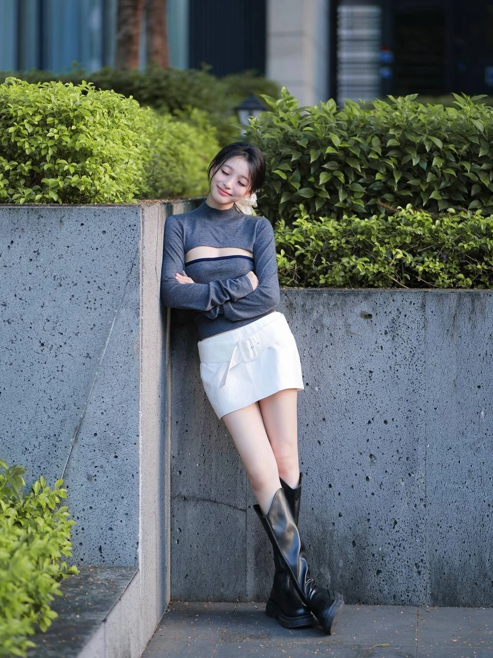 一位穿着灰色衬衫和白色衬衫的女人坐在地上。