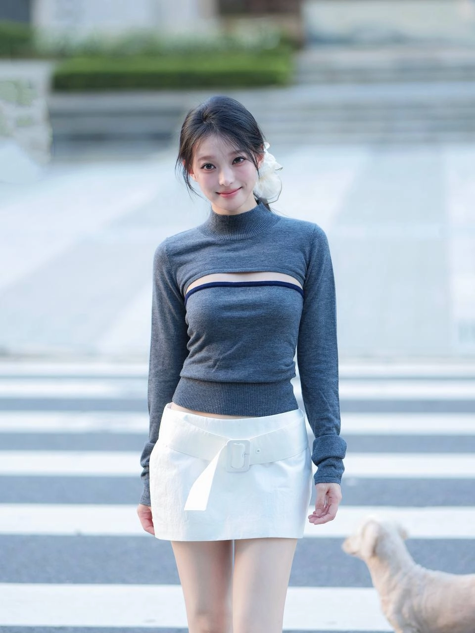 一位穿着灰色衬衫和白色衬衫的女人坐在地上。