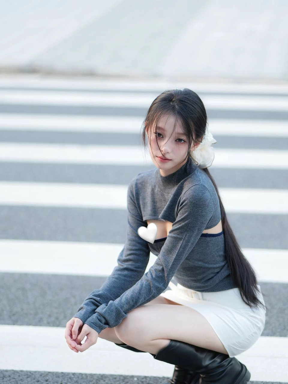 一位穿着灰色衬衫和白色衬衫的女人坐在地上。