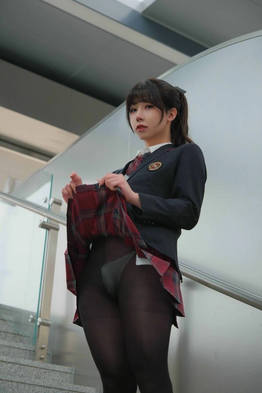 女人穿着一件黑色夹克和一件红色的裙子。