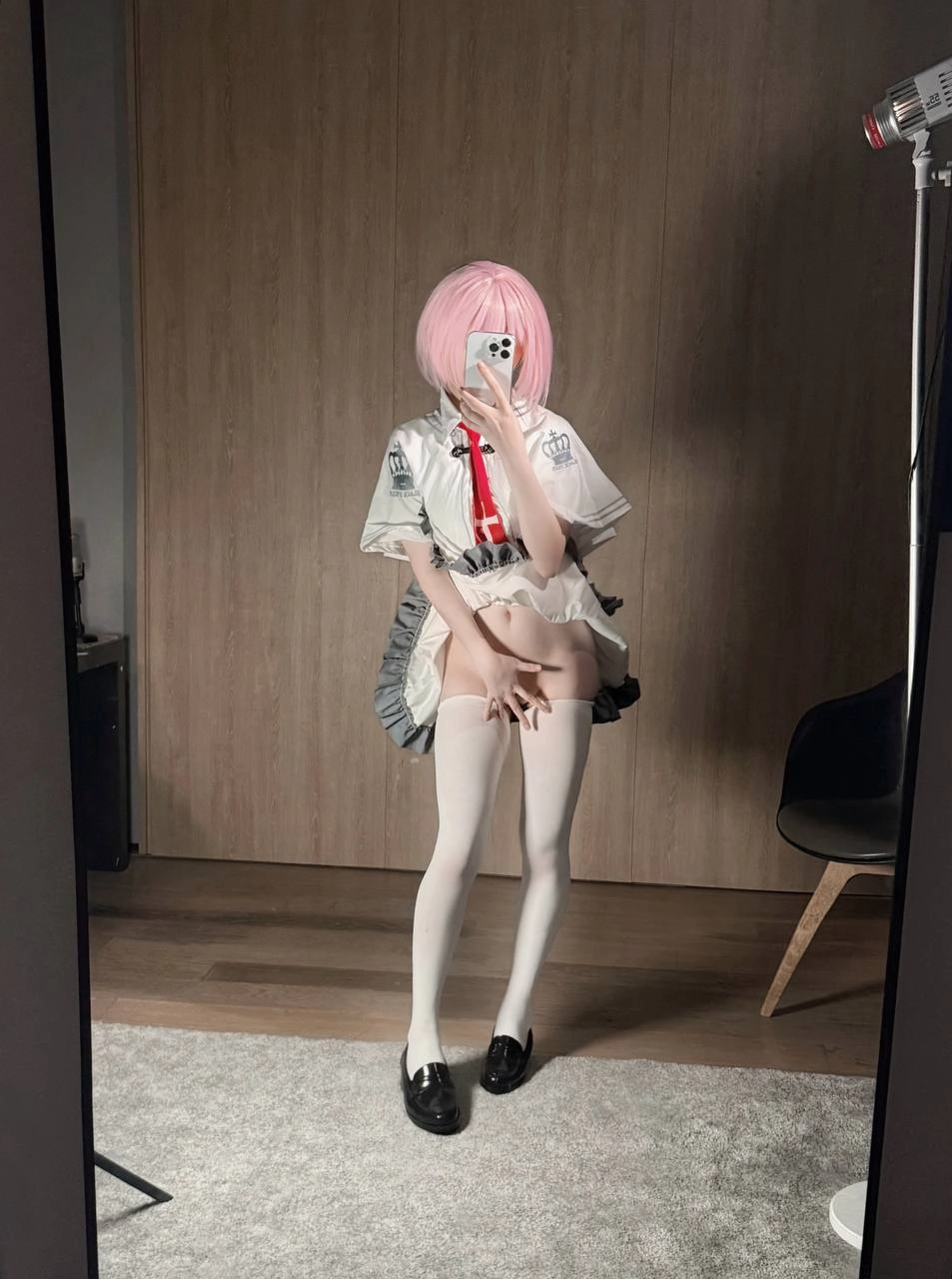 穿着粉红色毛衣和白色衬衫的女人拍了一张自拍。