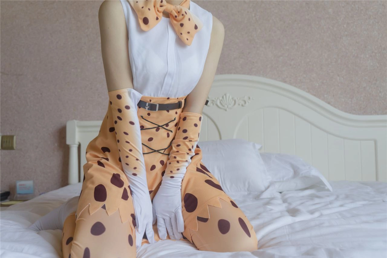 一位穿着一件黑衣印刷服装的女人坐在床上。