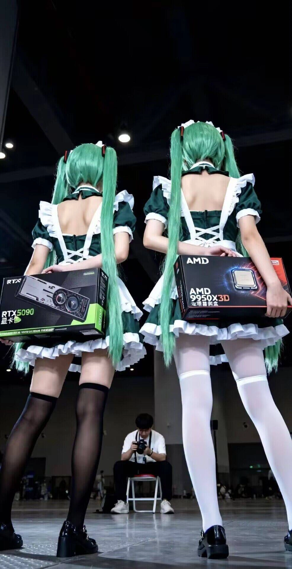 两个女人拿着盒子,上面写着“AMD”。