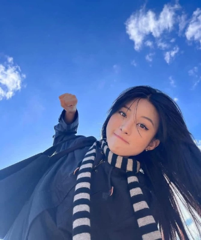 一位紫色头发和一件白色衬衫的女孩正在空中飞翔。