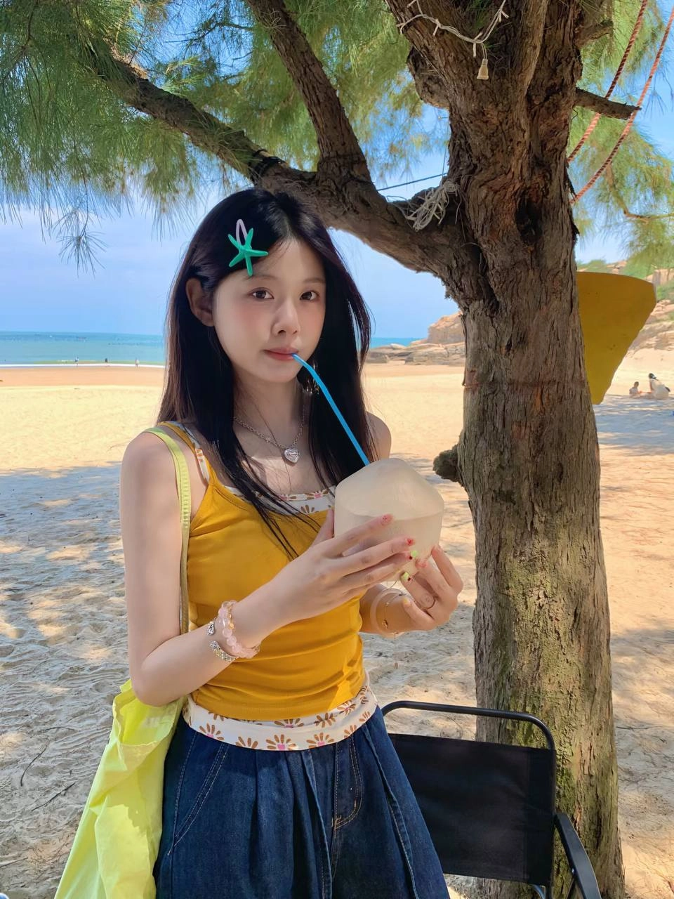 女人拿着一个椰子饮料与一根子。