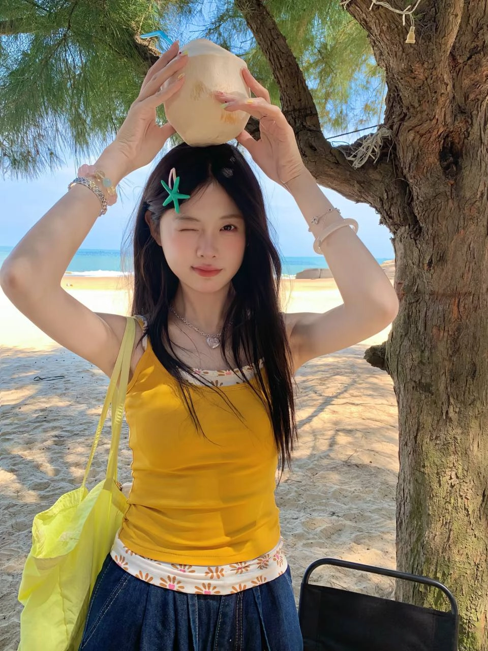 女人拿着一个椰子饮料与一根子。