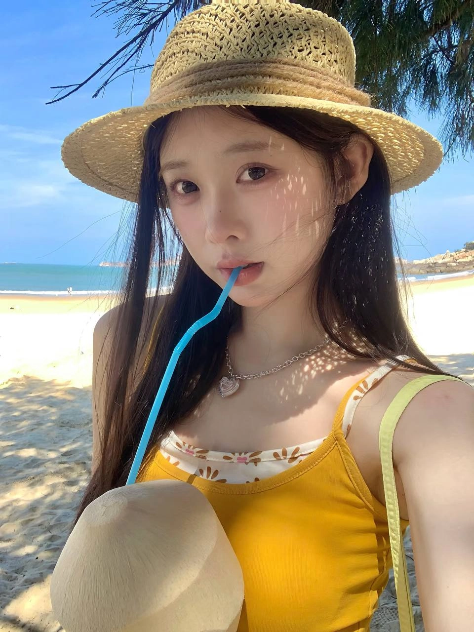 女人拿着一个椰子饮料与一根子。