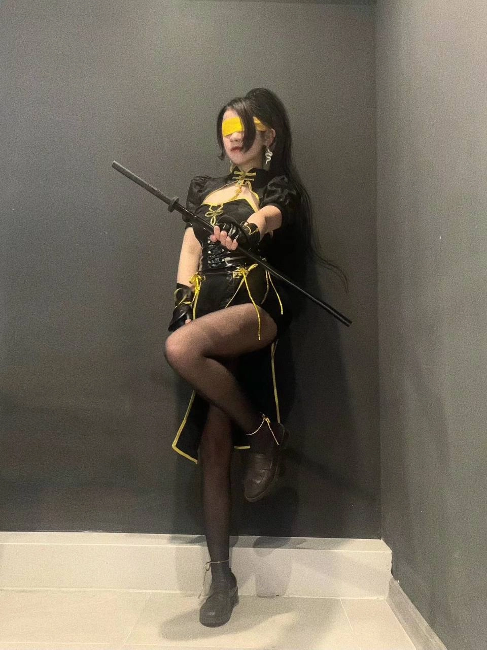 穿着黑色和黄色的女士拿着一把剑。