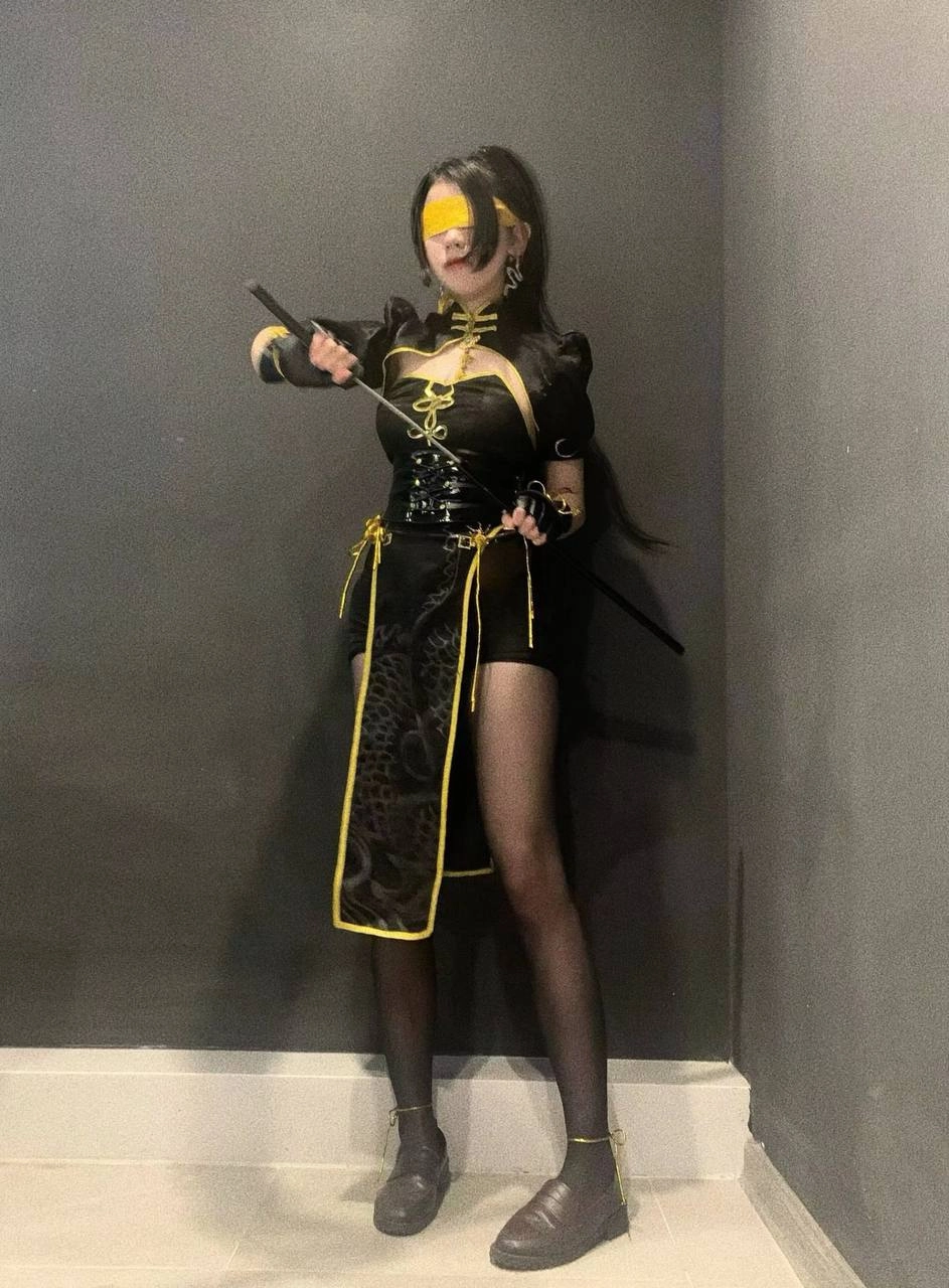 穿着黑色和黄色的女士拿着一把剑。