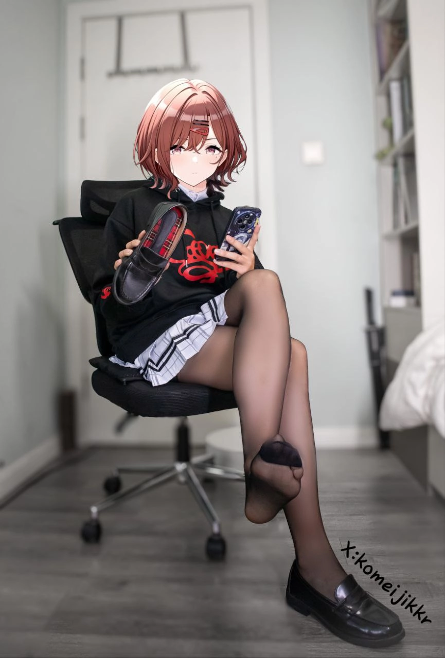 穿着红色标志的黑色毛衣的女孩坐在床上。