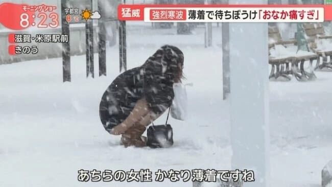 穿着黑色外套的女人站在雪地上。