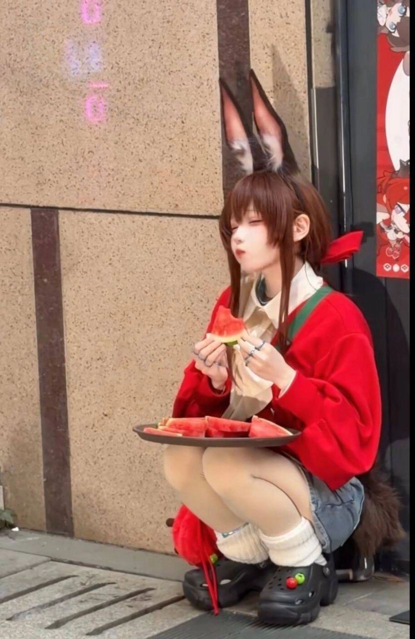 穿着红色衬衫的女人吃水。