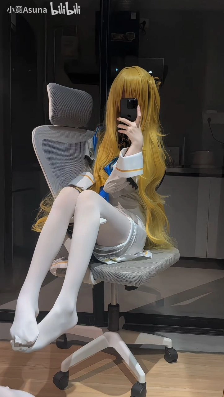 一位穿着白色和蓝色裙子的女人正在拍照。