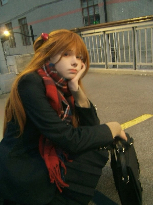 长长的头发和一件红色的衬衫的女人坐在地上。