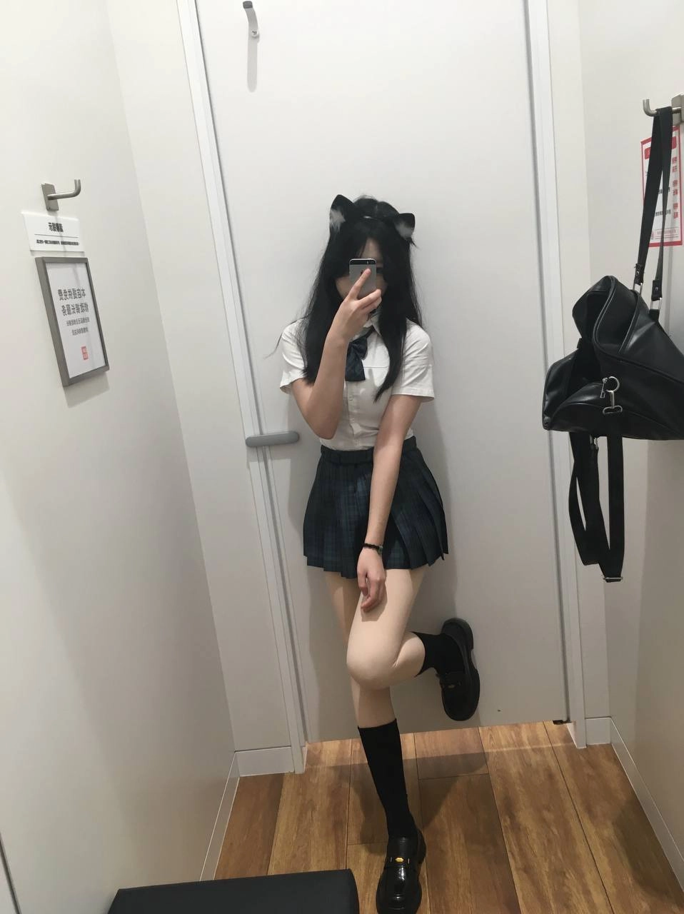 一位穿着白色衬衫和黑色衬衫的女人坐在椅子上。