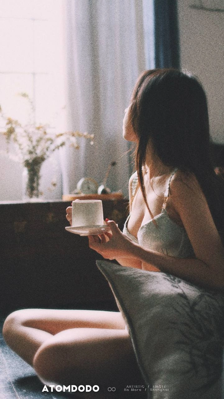 穿着手的女人握着一个杯子。