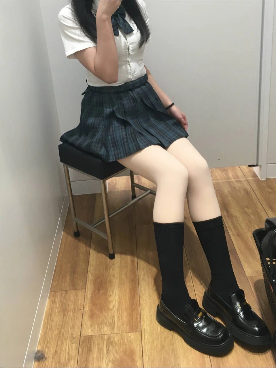 一位穿着白色衬衫和黑色衬衫的女人坐在椅子上。