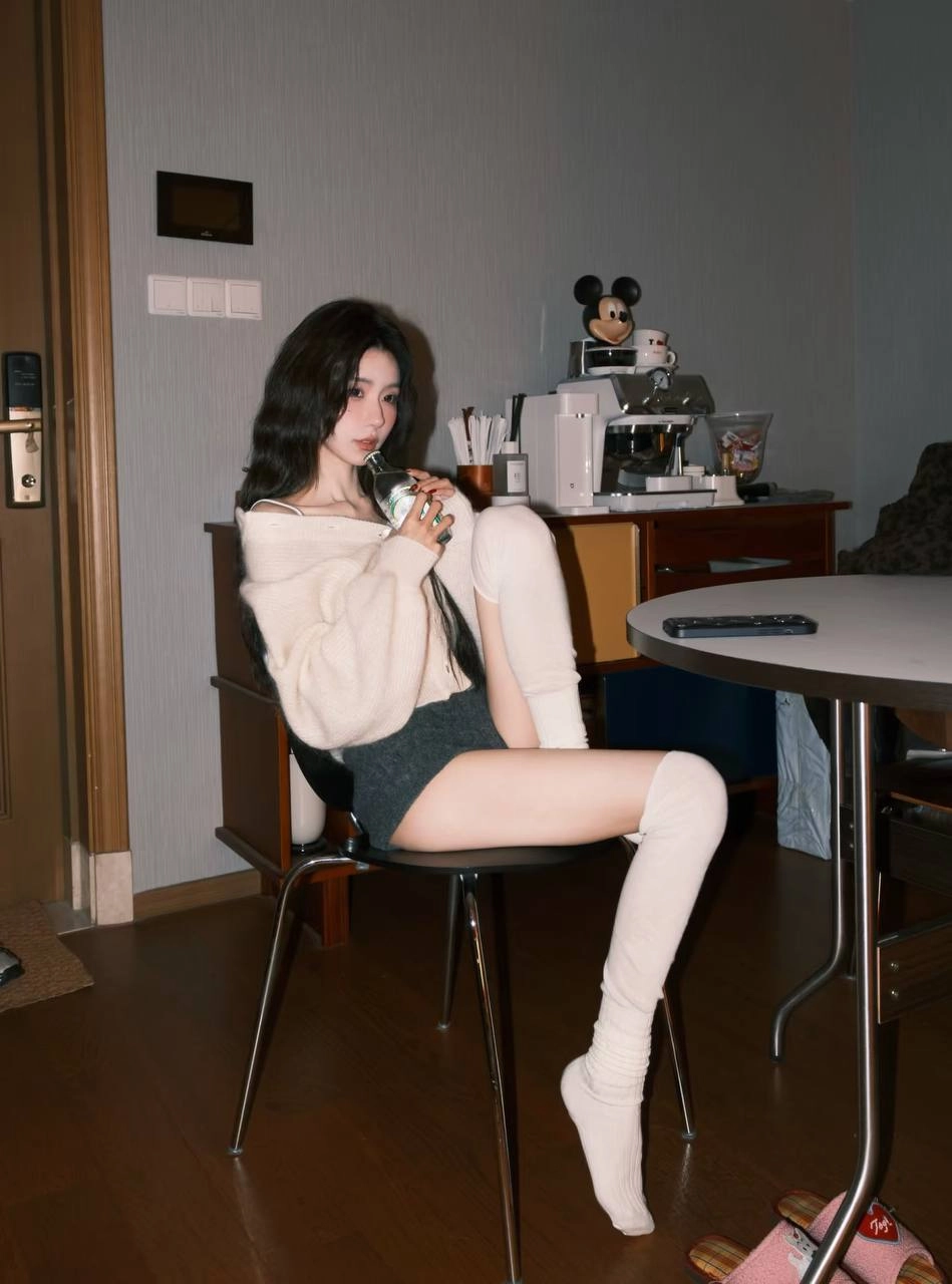 穿白色衬衫和黑色短裤的女人坐在一张桌子上。