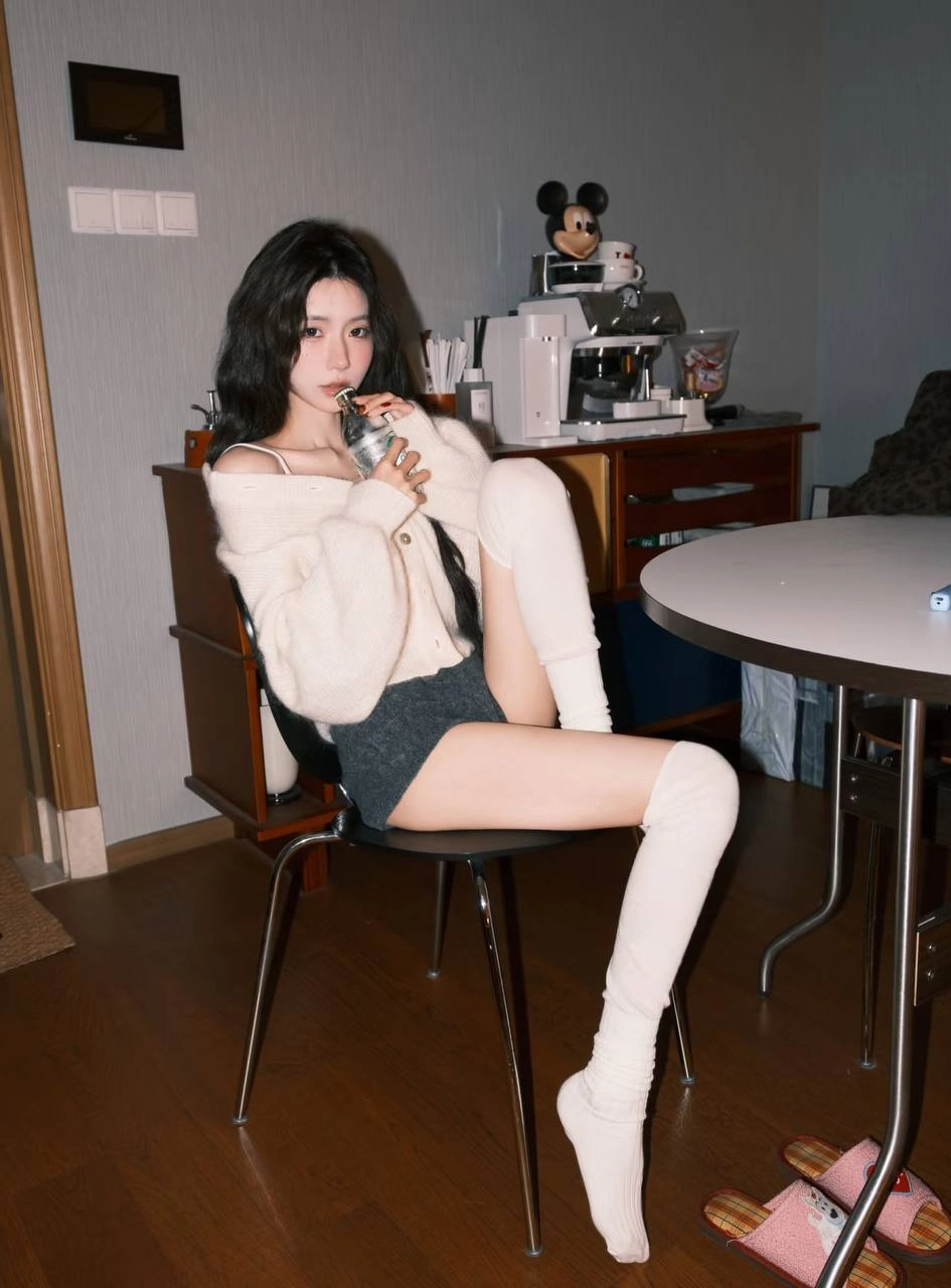 穿白色衬衫和黑色短裤的女人坐在一张桌子上。