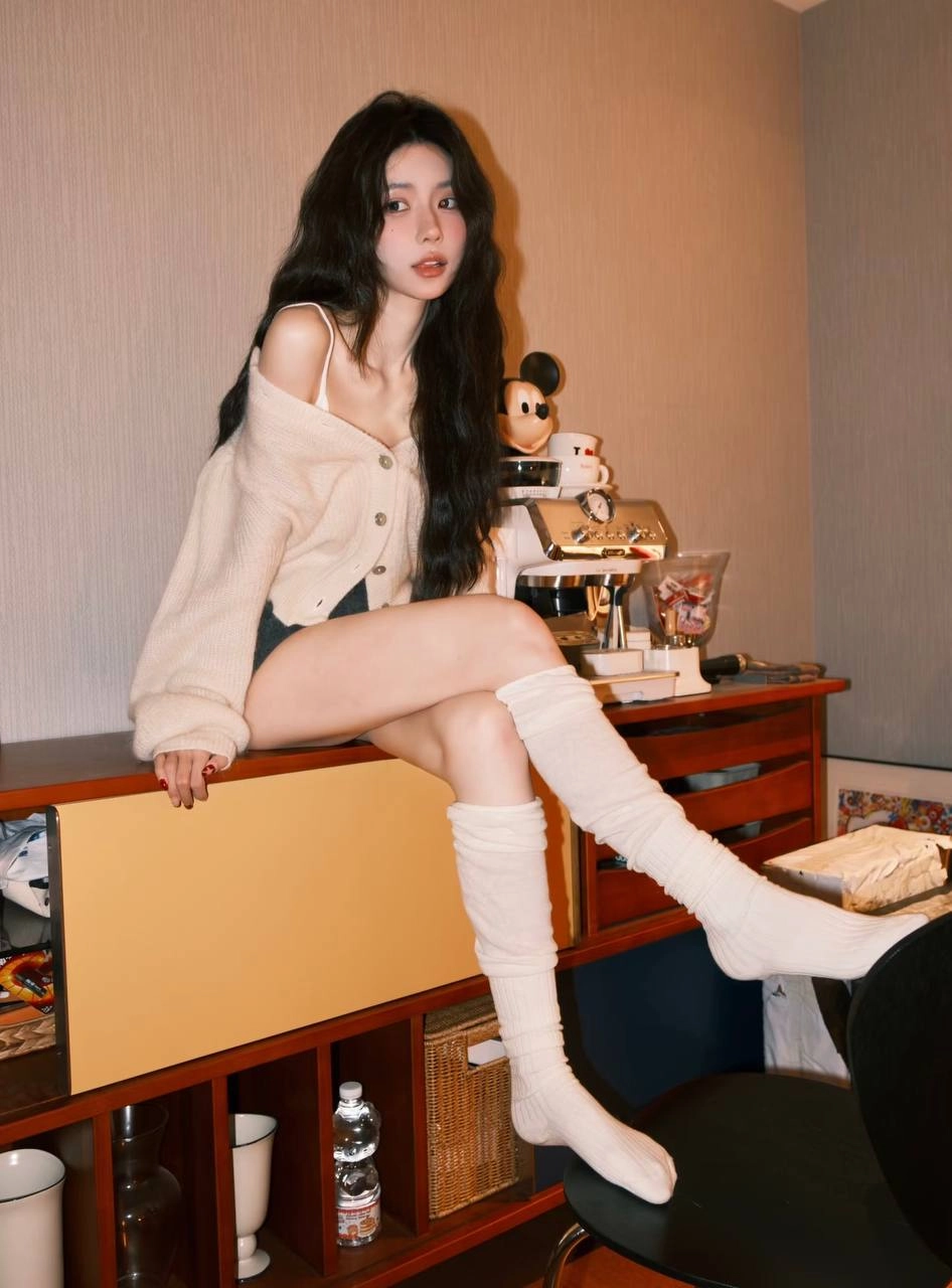 穿白色衬衫和黑色短裤的女人坐在一张桌子上。