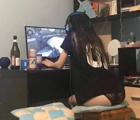 一位穿着黑色衬衫和耳机的女人正在玩视频游戏。