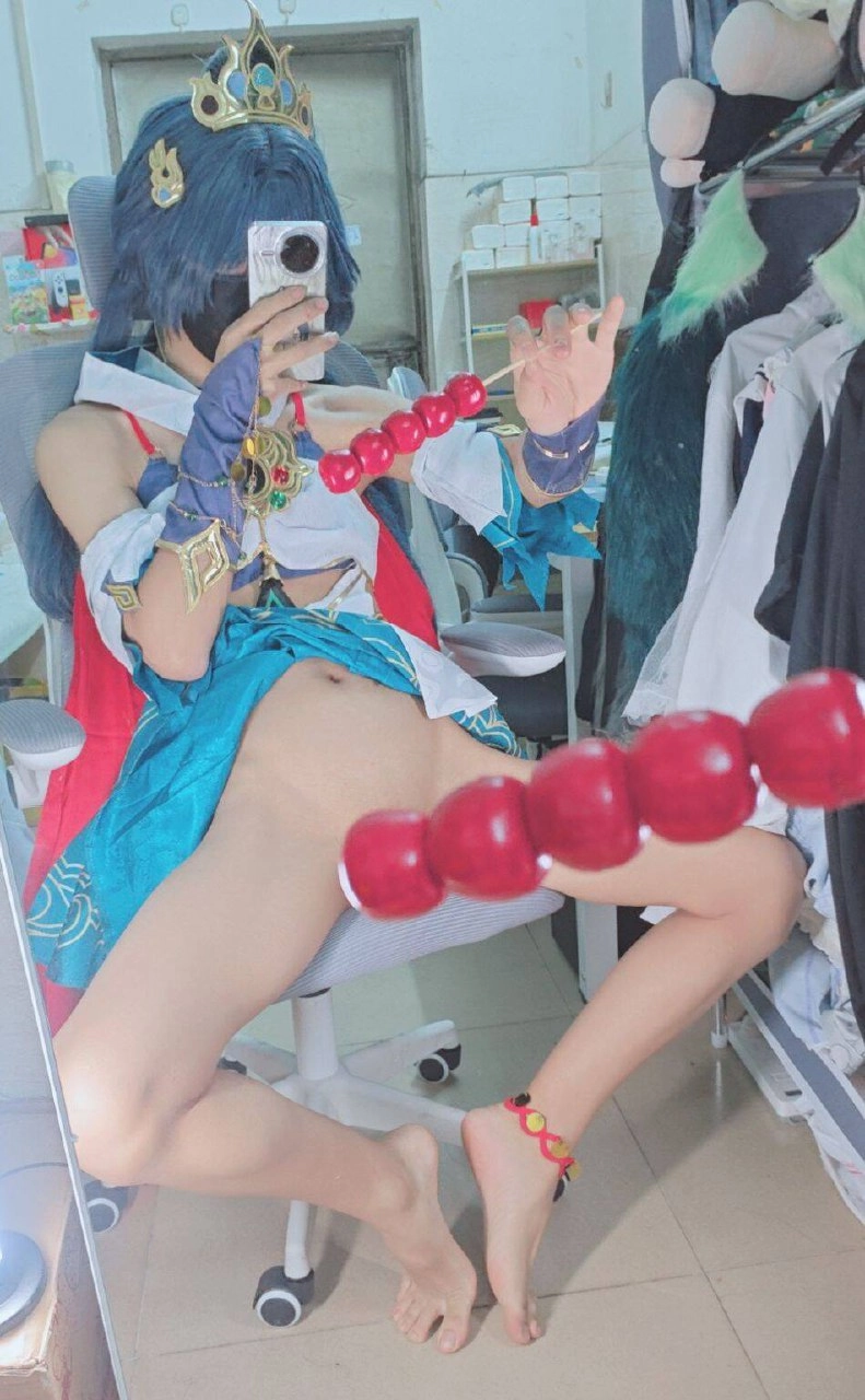 一位穿着蓝色衣服的女人正在用镜子拍照。