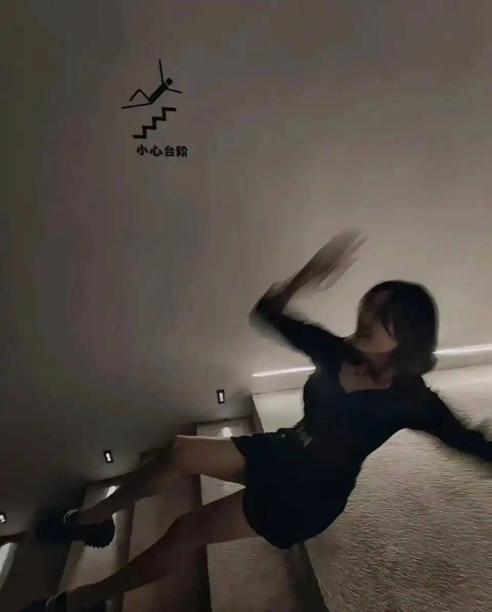 穿着黑色衣服的女人正在爬楼梯。