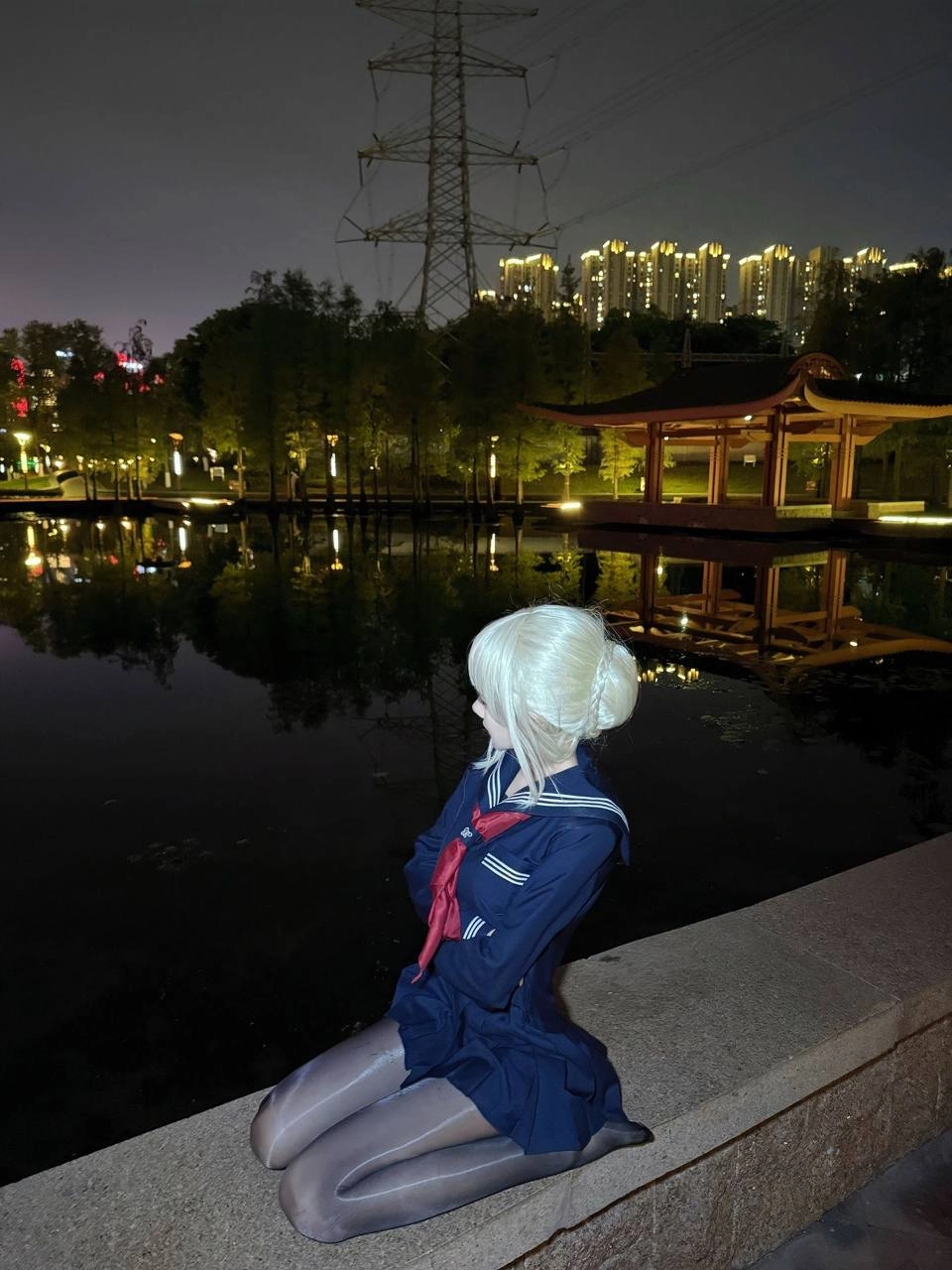 一位穿着蓝色衣服的女人坐在一片湖面上。