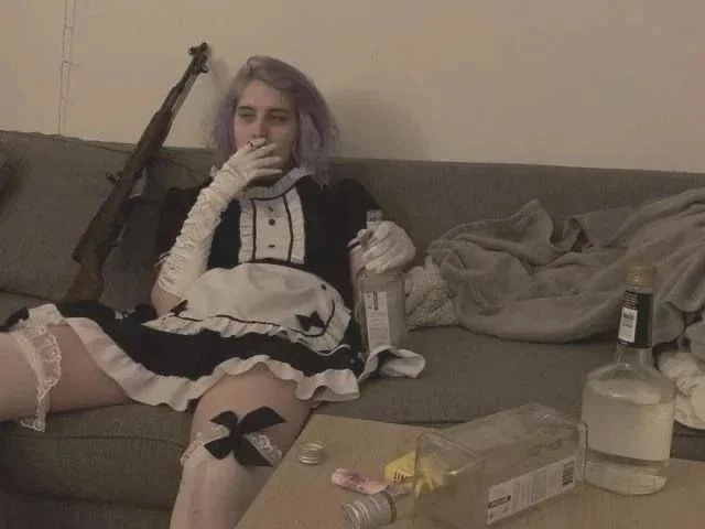 穿着女仆的衣服的女人坐在沙发上。