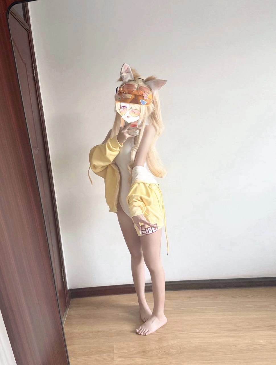 女人戴着猫面具和黄色夹克。