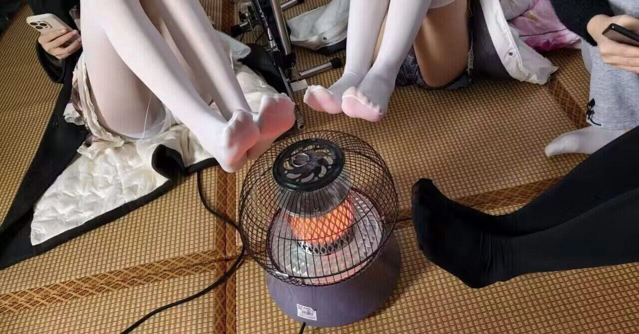 两个女孩坐在地板上,脚在空中。