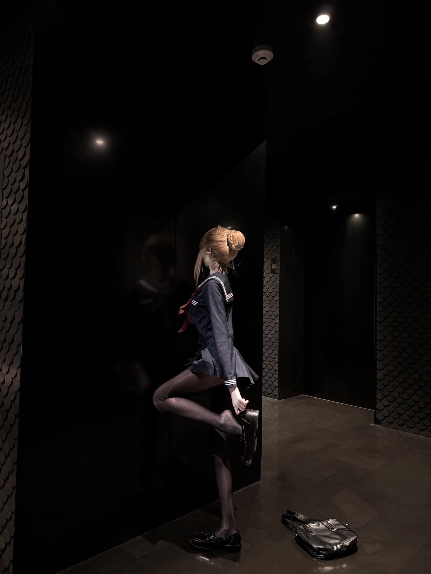 一位穿着蓝色水手服的女人站在走廊上。