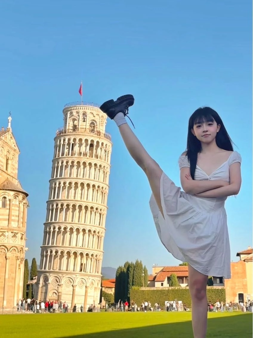 女人站在一个斜塔前面。