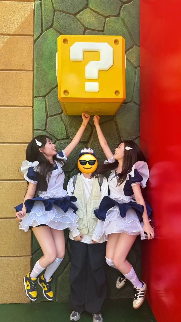 两个女孩在女仆服装玩视频游戏。