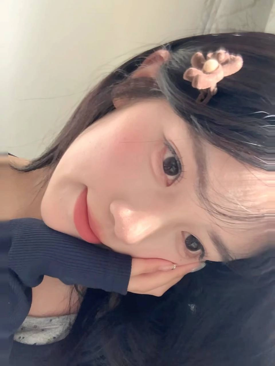 一位黑头发和粉红色的唇膏的女人在相机前微笑。