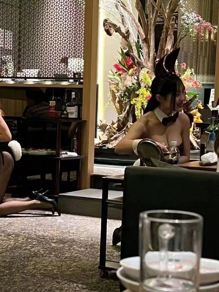 穿兔子服的女人坐在一张桌子上。