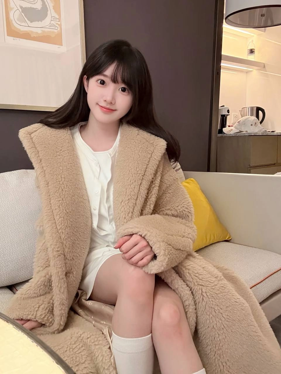 戴着马尾巴和棕色外套的女孩微笑着。